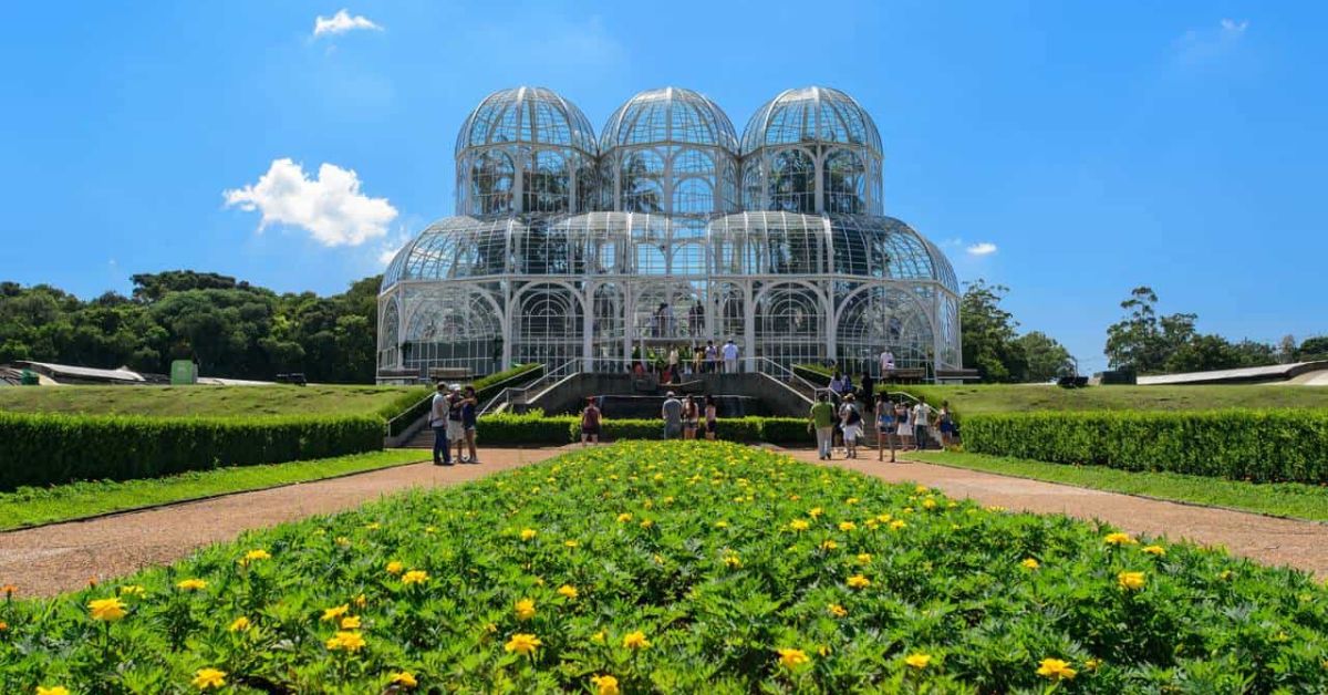 Estufa do Jardim Botânico de Curitiba, símbolo da capital mais ecológica do Brasil, cercada por áreas verdes e visitantes