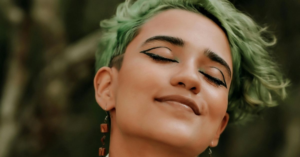 Pessoa de olhos fechados representando a cor que vemos ao fechar os olhos em ambiente de baixa luminosidade