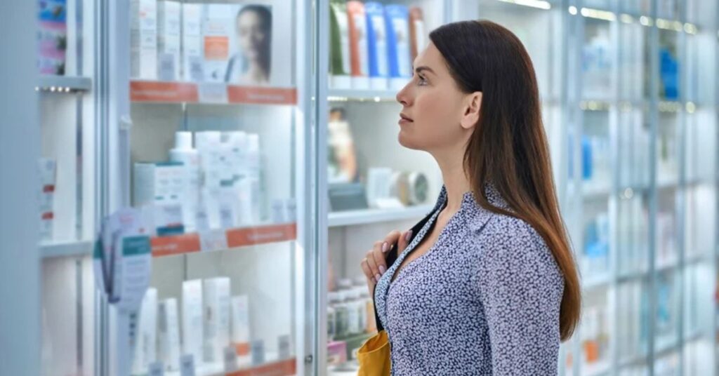 Consumidora analisando cosméticos sem testes em animais em prateleira de farmácia