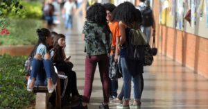 estudantes em campus universitário consultam cursos disponíveis no Sisu 2026