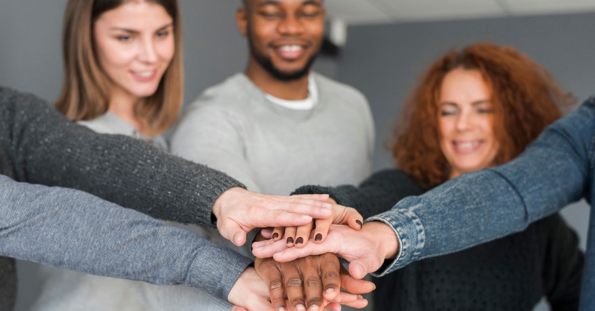 Equipe diversa celebrando igualdade de gênero nas empresas com união de mãos