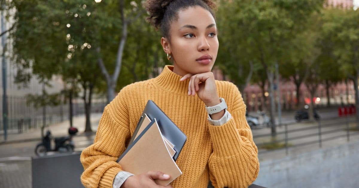 Estudante planejando o ingresso no ensino superior com cadernos e tablet