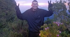 Jovem encontrado vivo no Pico Paraná Roberto Farias Tomaz sorrindo durante trilha na montanha