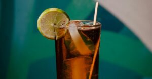 Parar de beber refrigerante representado por copo com gelo e limão sobre a mesa