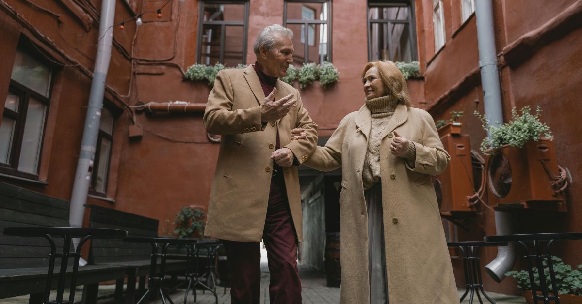 Casal de idosos caminha e conversa em ambiente urbano, exemplo de bem-estar associado às zonas azuis do planeta