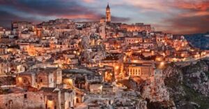 Matera iluminada ao entardecer eleita uma das 7 Maravilhas do Mundo em 2026