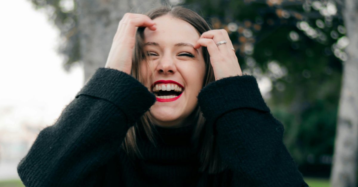 Mulher sorrindo ao ar livre representando equilíbrio dos níveis de dopamina