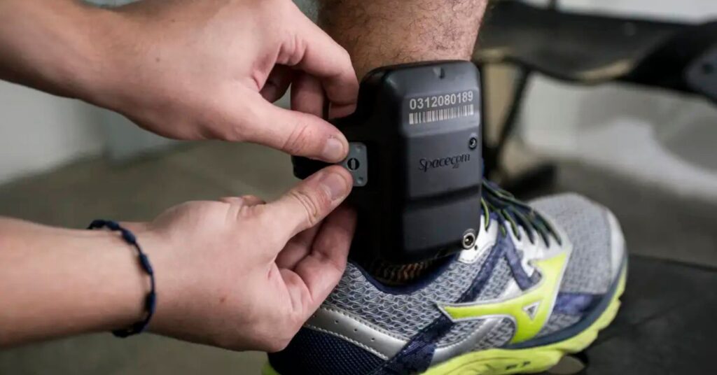 agressor de mulher com tornozeleira eletrônica sendo instalada para monitoramento