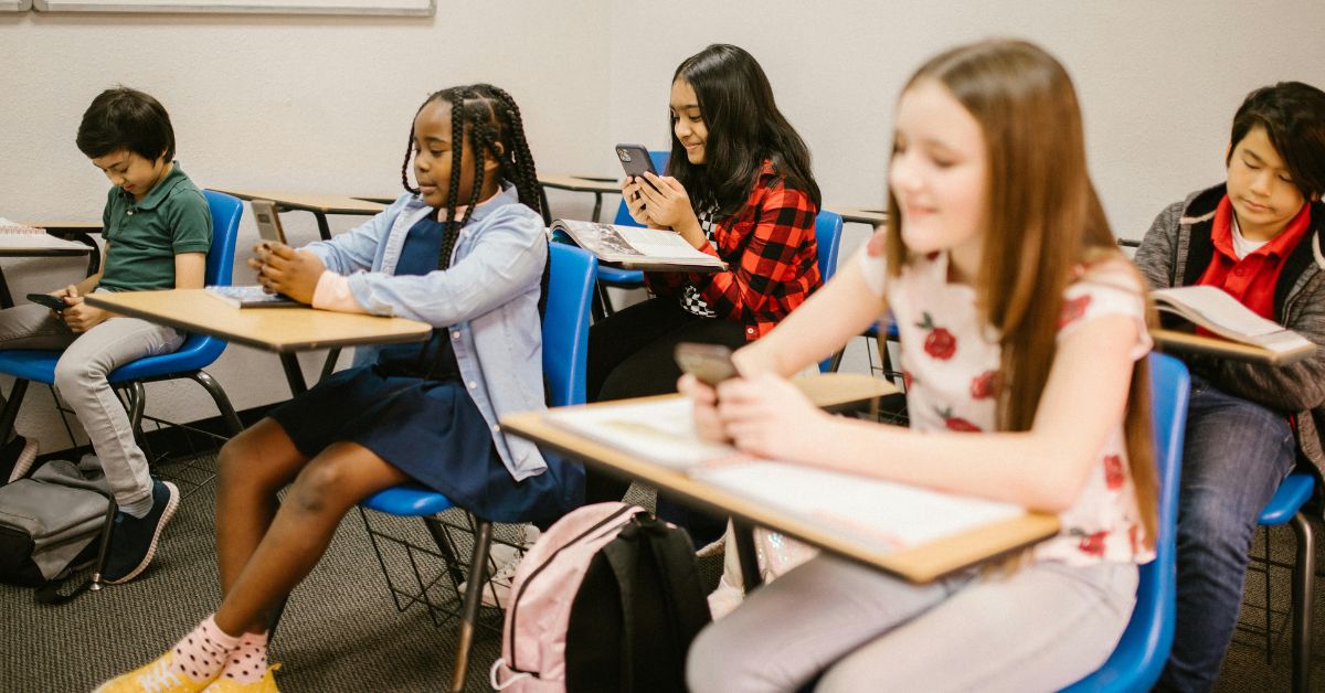 Crianças usando celular em sala de aula após novas regras do ECA Digital