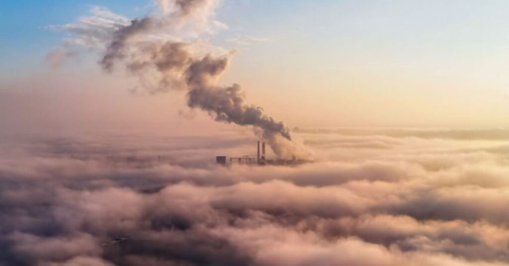 Chaminés industriais emitindo fumaça, ilustrando Gases do efeito estufa no Brasil e os desafios da descarbonização