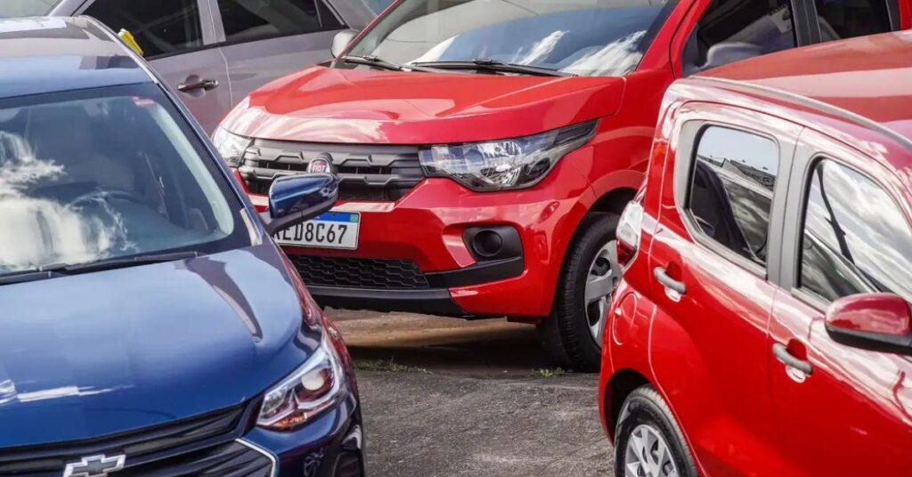 carros mais econômicos circulando em rodovia com tráfego urbano ao entardecer