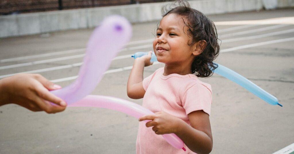 criança brincando com balões em ambiente seguro, reforçando prevenção de maus-tratos contra criança