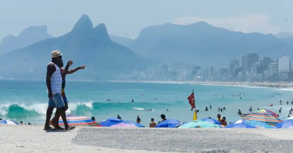 turistas estrangeiros aproveitando praia no Rio de Janeiro com vista para o mar e montanhas