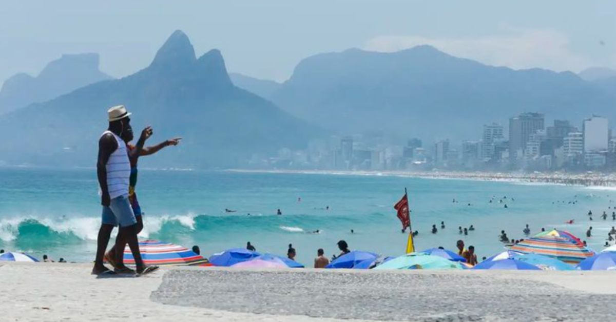 turistas estrangeiros aproveitando praia no Rio de Janeiro com vista para o mar e montanhas
