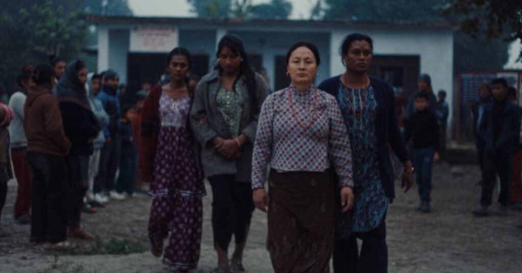 Cena do filme Elefantes na Névoa, coprodução brasileira em Cannes, com mulheres caminhando em comunidade rural