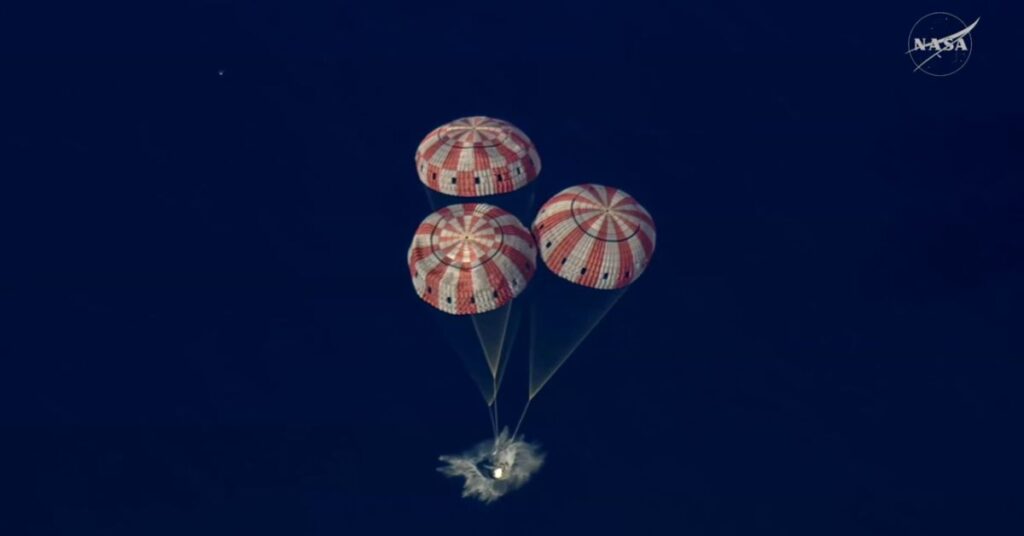 Cápsula Orion da missão Artemis II retornando à Terra com paraquedas no Oceano Pacífico