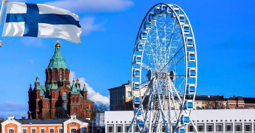 Roda-gigante e bandeira da Finlândia em Helsinque, destino para quem deseja trabalhar na Finlândia