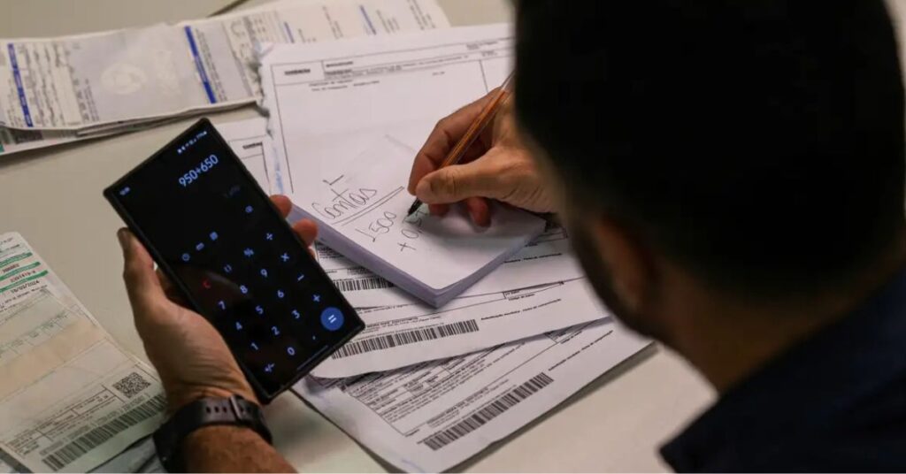 Consumidor calcula dívidas no celular durante renegociação pelo Desenrola 2.0