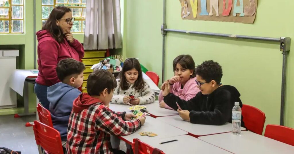 Professora acompanha estudantes superdotados em atividade escolar após aprovação de política nacional para altas habilidades
