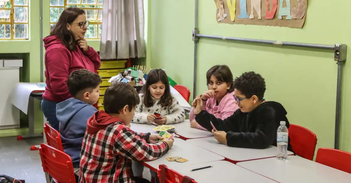 Professora acompanha estudantes superdotados em atividade escolar após aprovação de política nacional para altas habilidades