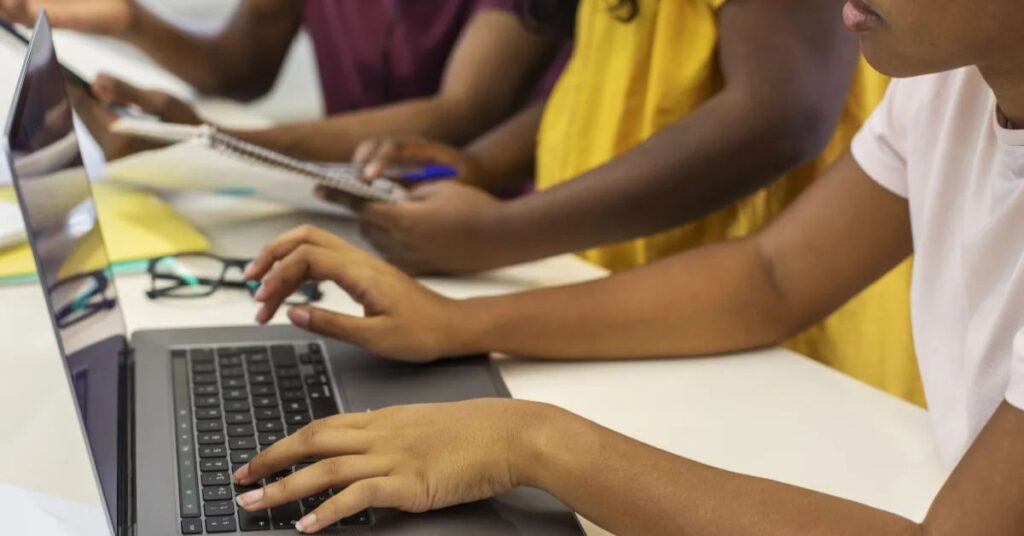 Estudantes utilizam computadores durante atividade sobre inteligência artificial na educação brasileira