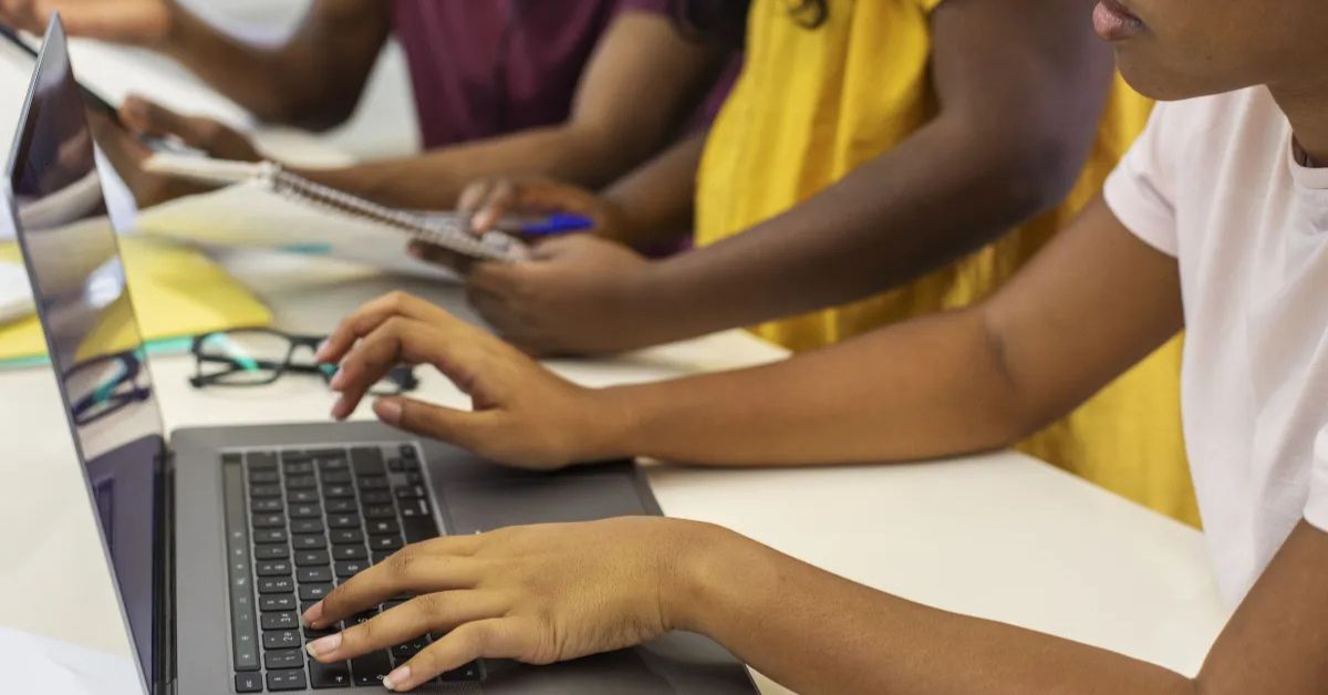 Estudantes utilizam computadores durante atividade sobre inteligência artificial na educação brasileira