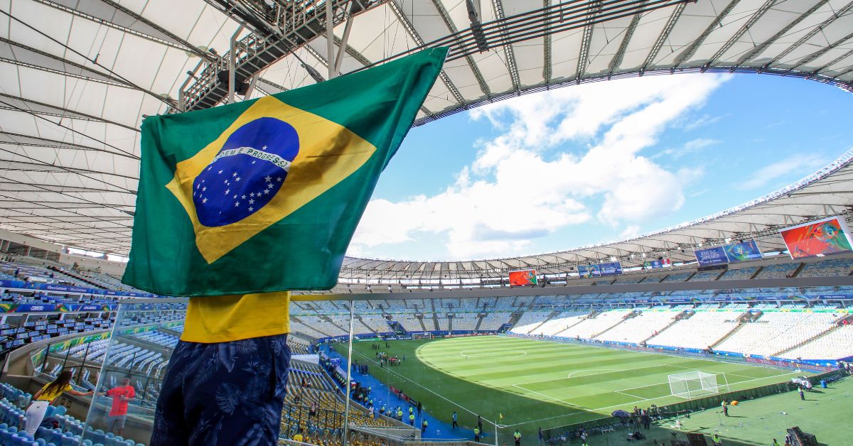 Torcedor com a bandeira do Brasil no Maracanã durante a celebração da história da Seleção Brasileira no estádio que chega a 120 jogos