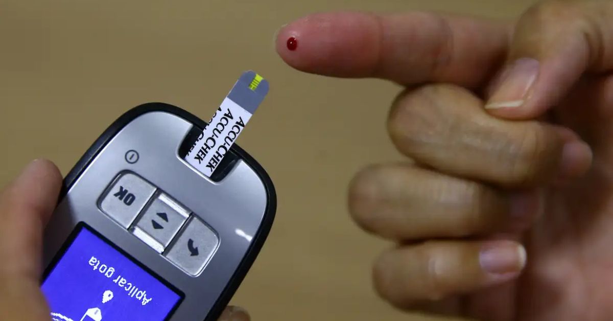 Paciente faz medição de glicose com aparelho de monitoramento em matéria sobre sensores inteligentes no diabetes