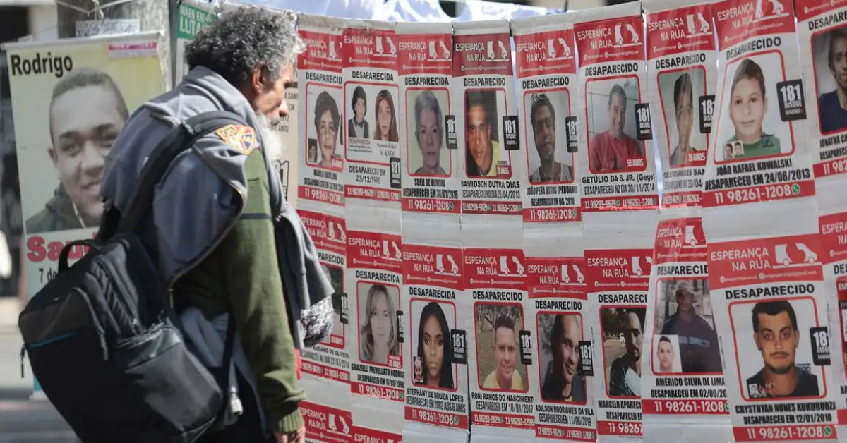 Painel com fotos de pessoas desaparecidas em ato de conscientização sobre a busca de pessoas desaparecidas no Brasil e apoio às famílias.