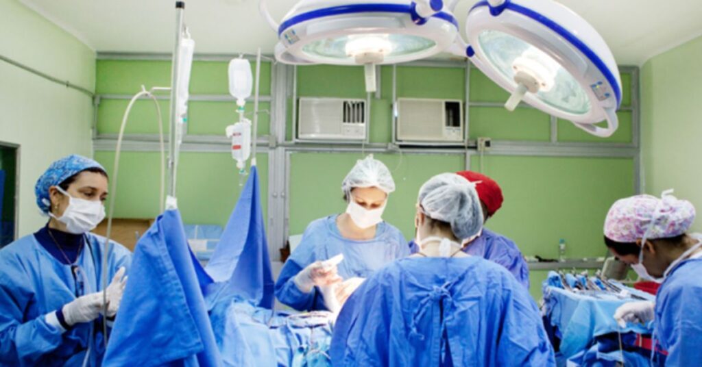 Equipe médica realiza procedimento em centro cirúrgico de hospital público durante ampliação das cirurgias no SUS.