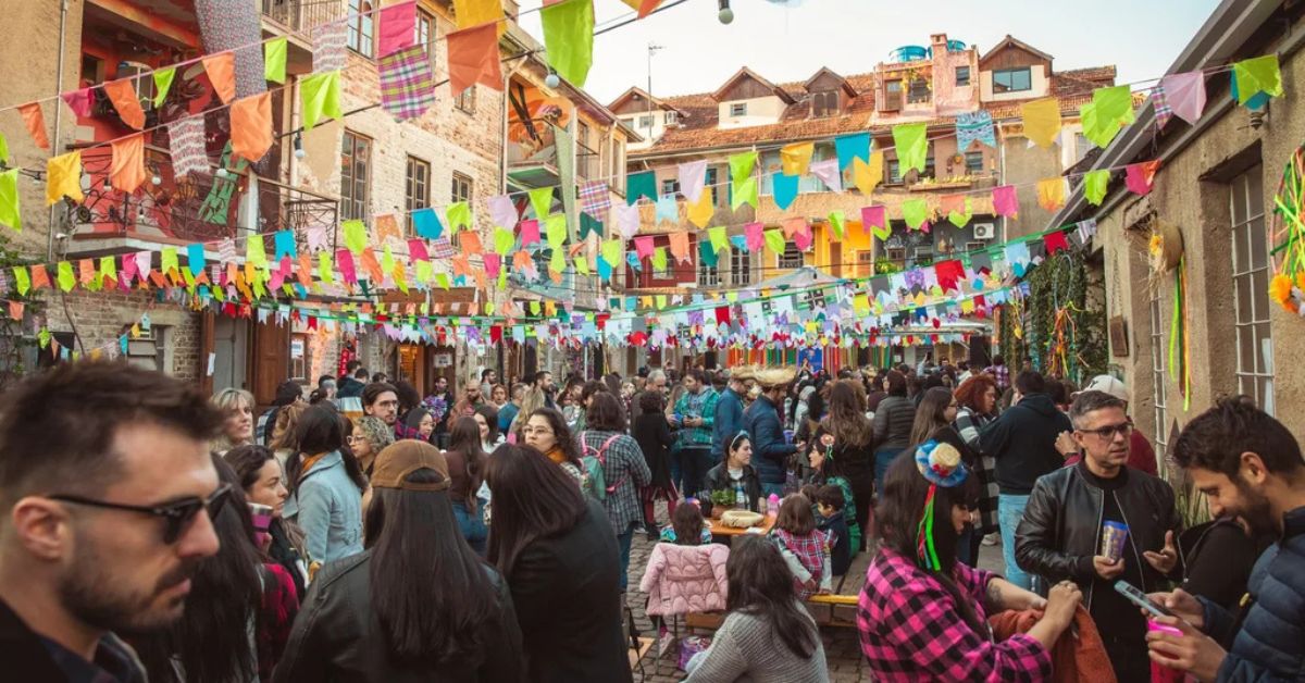 Multidão participa das comemorações do Dia de São João em rua decorada com bandeirinhas coloridas durante festa junina tradicional