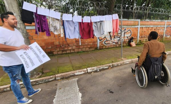 O servidor entrega roupa e ajuda na distribuição de currículos.
