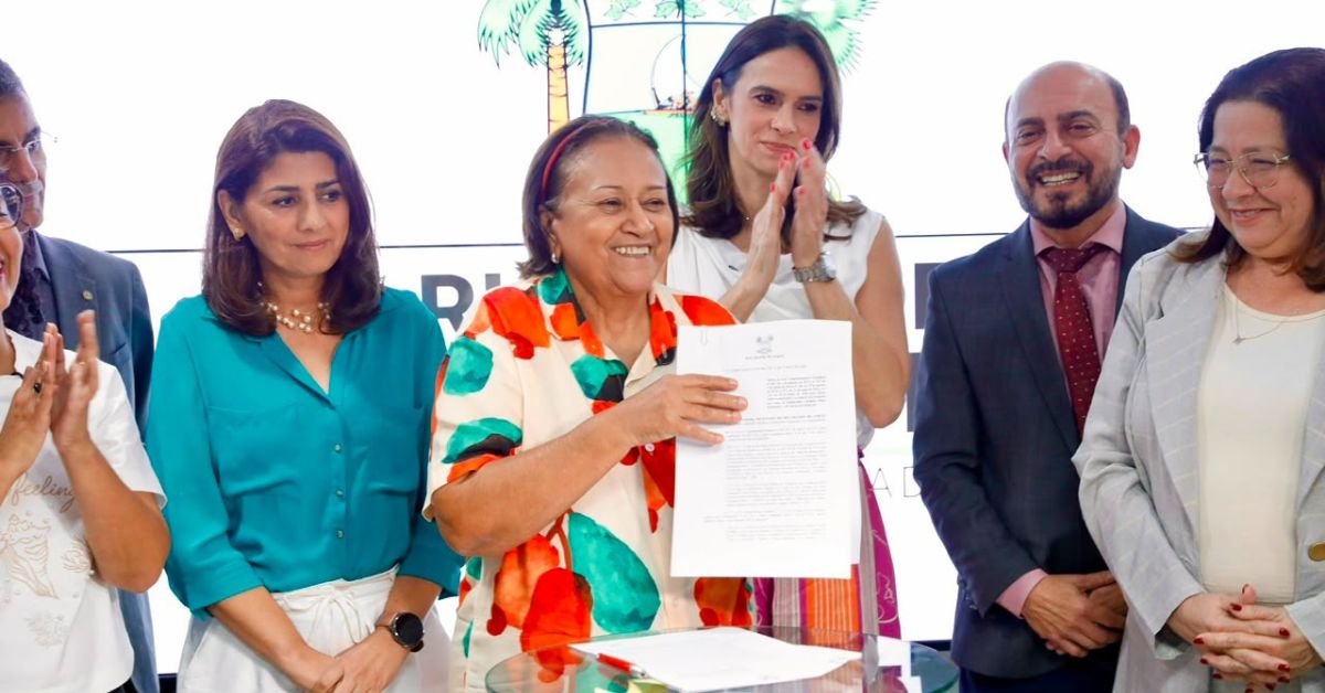 Governadora Fátima Bezerra exibe documento da Lei contra feminicídio durante cerimônia de sanção no Rio Grande do Norte.