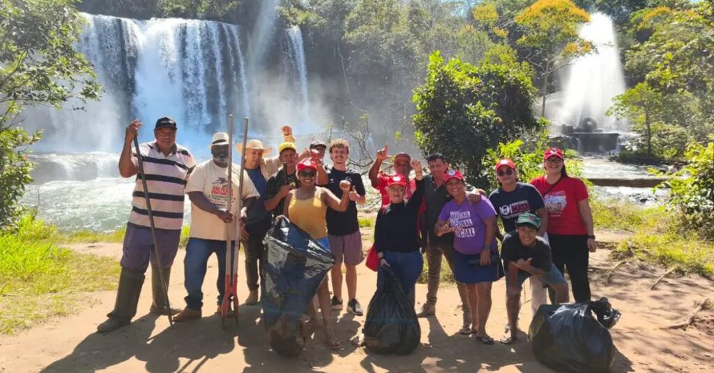 Participantes da mobilização ambiental do MST realizam ação de preservação da natureza durante o plantio de árvores no Brasil em área próxima a cachoeira.