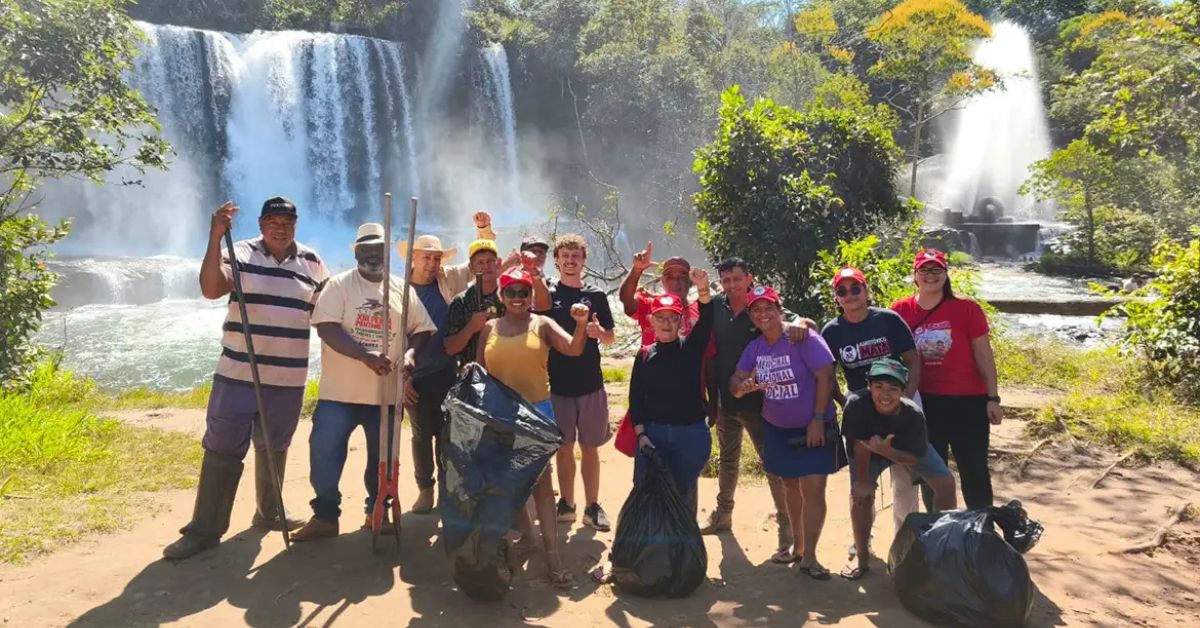 Participantes da mobilização ambiental do MST realizam ação de preservação da natureza durante o plantio de árvores no Brasil em área próxima a cachoeira.