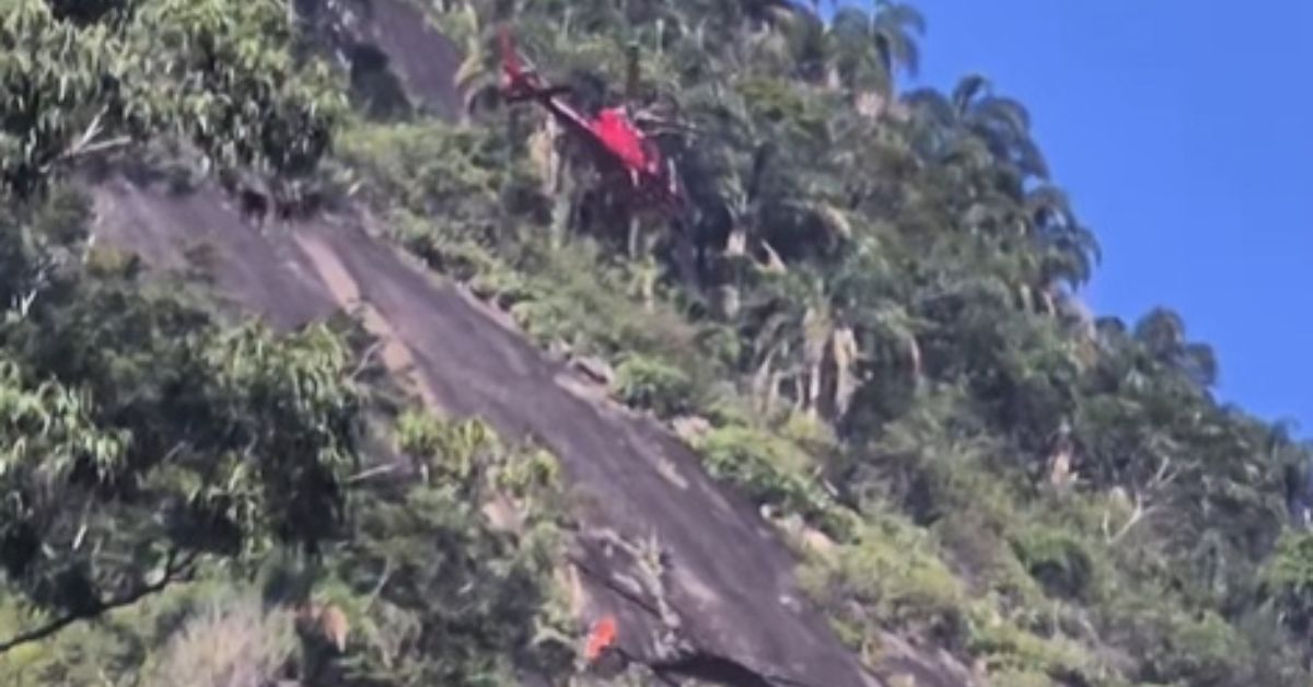 Helicóptero do Corpo de Bombeiros realiza resgate em montanha no Rio de Janeiro durante operação aérea para retirar escalador ferido em área de difícil acesso no Cosme Velho.