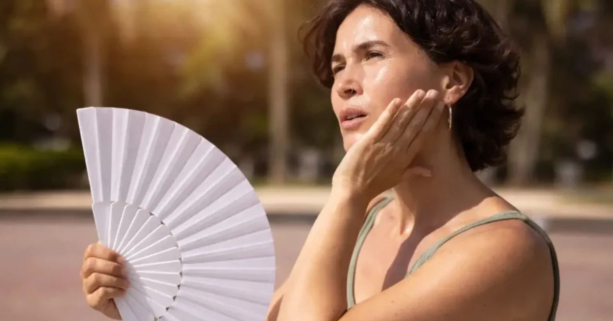 Mulher durante episódio de ondas de calor associado à menopausa, condição que pode ser tratada com tratamento não hormonal menopausa aprovado pela Anvisa.