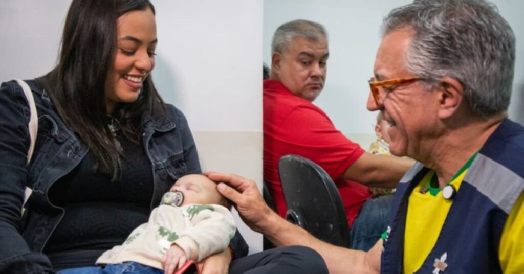 Profissional de saúde conversa com mãe e bebê durante aplicação da vacina contra pneumonia e meningite no SUS.