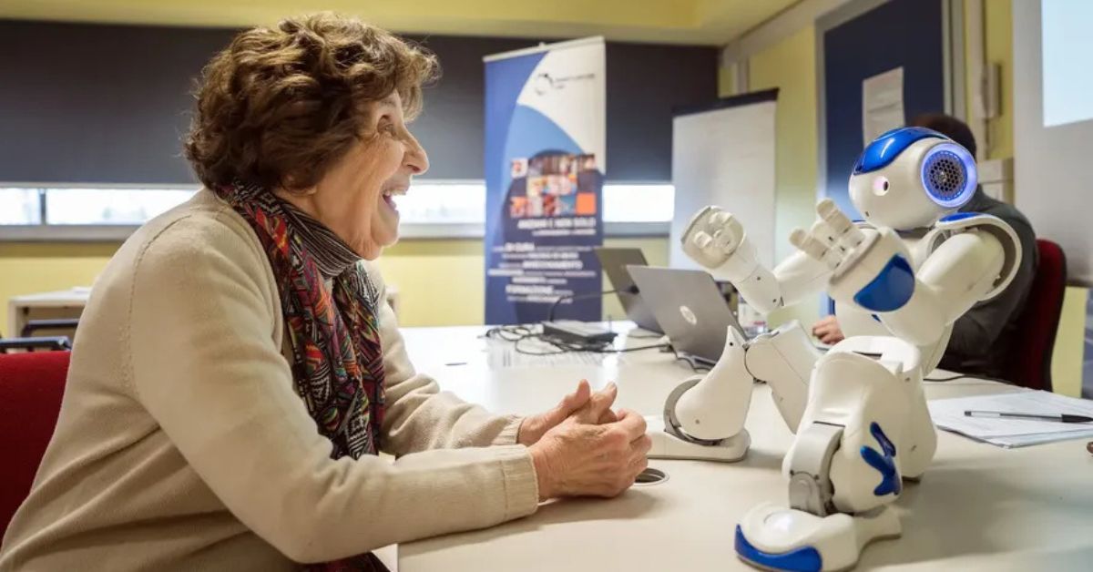 Robô para idosos conversa com uma mulher durante demonstração de tecnologia voltada ao apoio e à companhia de pessoas idosas.