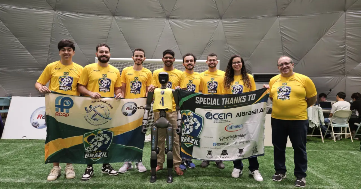 Integrantes da seleção brasileira de robôs posam com robô humanoide e bandeiras do Team Brazil.