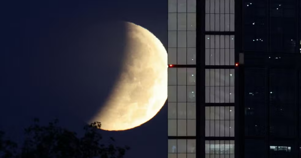 Eclipse lunar quase total deixa a Lua avermelhada no céu durante a madrugada no Brasil.