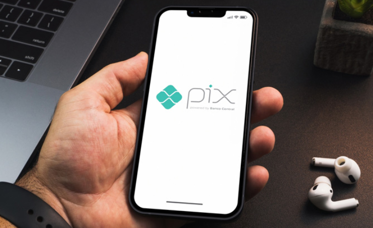 Pessoa usando celular para representar golpe pelo WhatsApp ou Pix e cuidados após fraude.