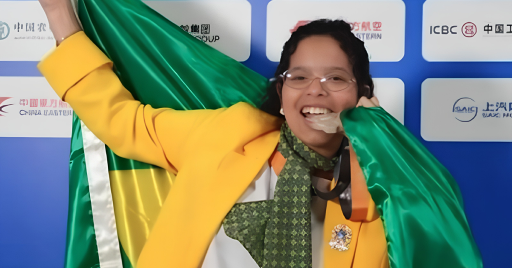 Myllena Vitória comemora medalha de prata na WorldSkills 2026 com a bandeira do Brasil.Myllena Vitória comemora a medalha de prata na WorldSkills 2026, em Shanghai, na China. Aos 21 anos, a jovem que aprendeu a costurar com o pai conquistou o segundo lugar mundial em Tecnologia da Moda.